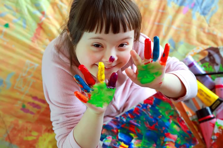 Child with additional needs playing with paint