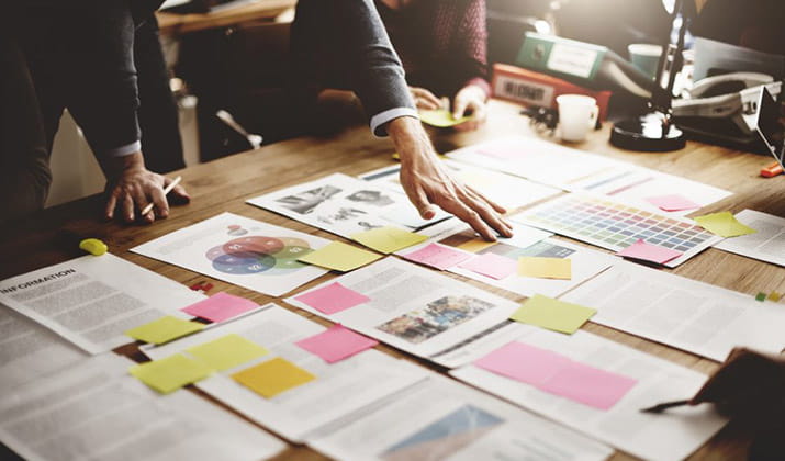 papers on desk with sticky notes