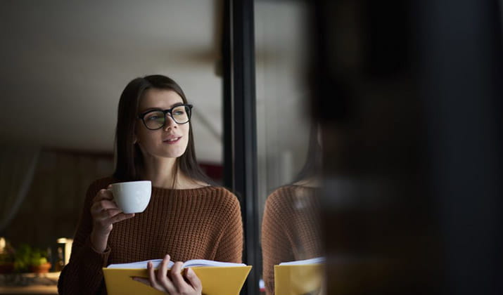 Female studying with coffee in hand