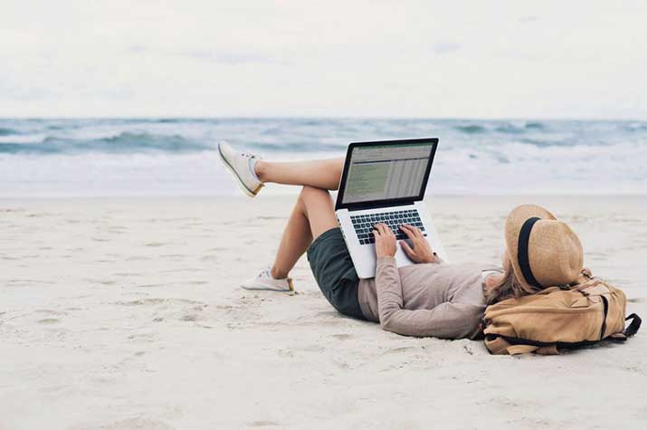 female-on-beach-on-laptop
