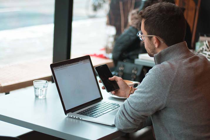 male-on-phone-and-laptop