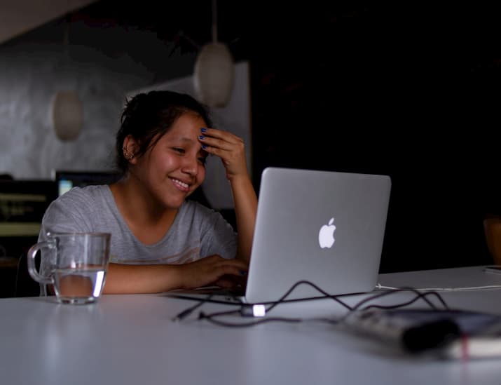 Girl looking at laptop screen smiling