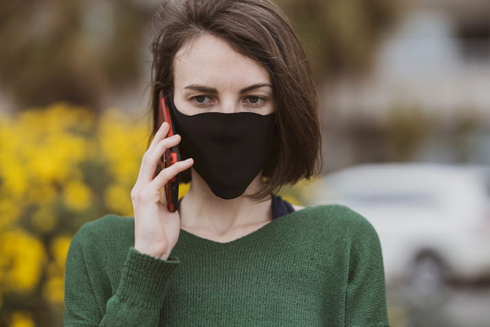 Woman talking on phone with mask