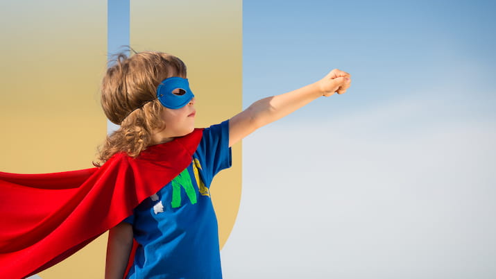 Kid in superman costume OUA logo