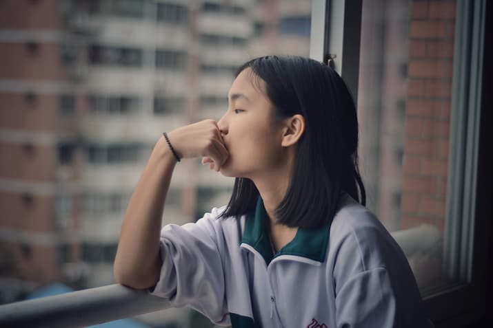 Young person looking out the window