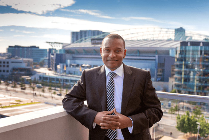 Edward Sadza standing in front of the Melbourne cityscape