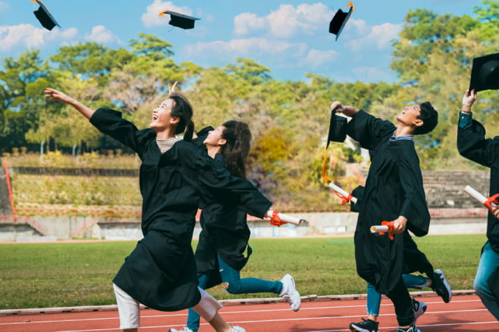 Happy graduates throwing their caps in the air