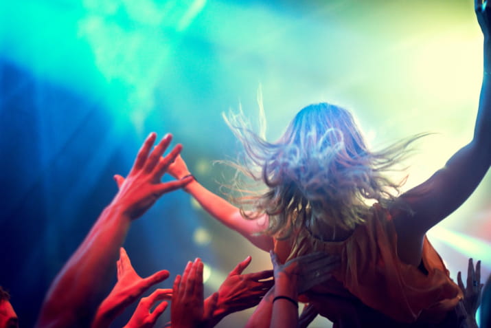A woman crowdsurfing at a concert
