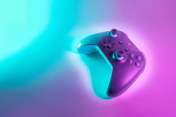 A Playstation console on a neon lit background