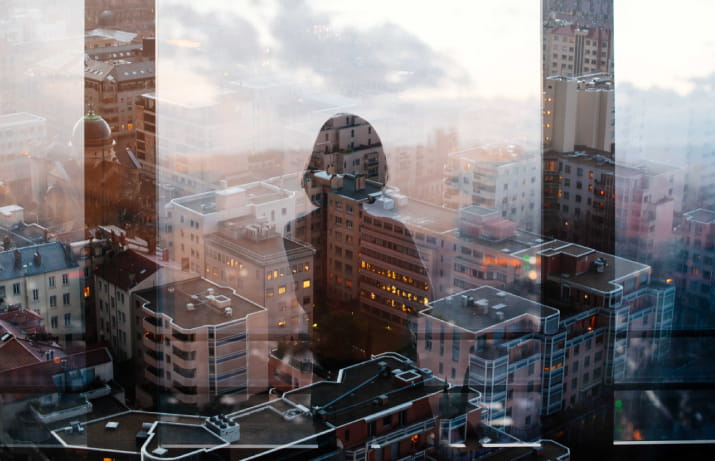 The silhouette of a woman overlooking a cityscape