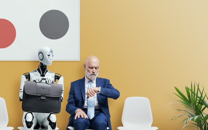 Man in suit sitting next to robot