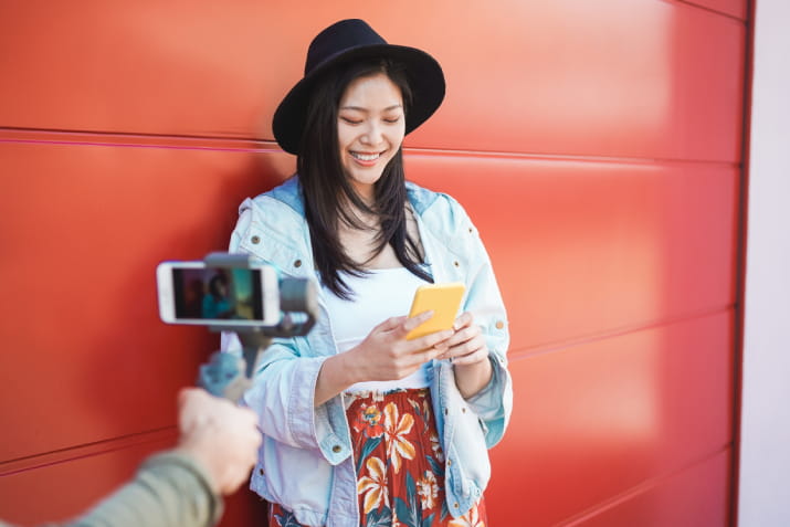 A woman smiling in front of a phone camera