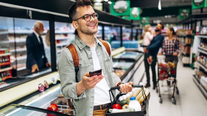 A happy nutritionist picking up healthy food at the supermarket