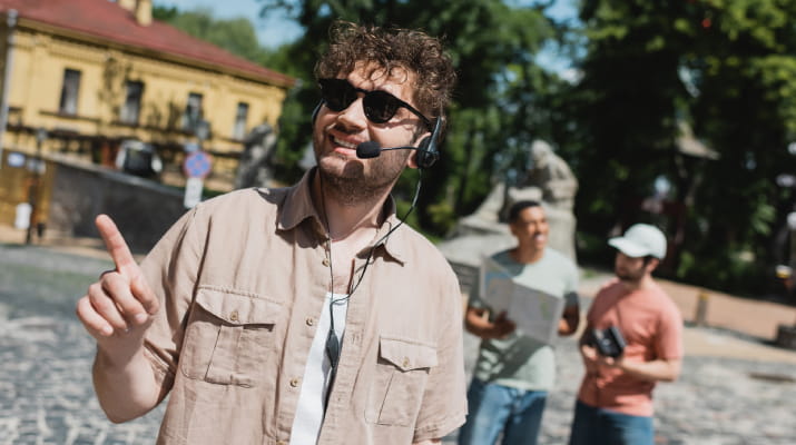 A fulfilled tour guide pointing out sights to tourists