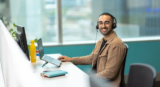 Open Universities Australia student advisor, Josh, seated at a workstation.