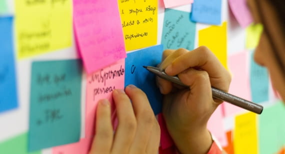 Person writing on sticky notes