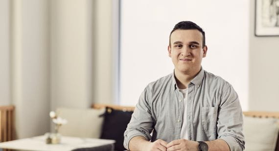 Business graduate Daniel seated at a table