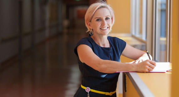 Open Universities Australia student Brenda wearing professional clothes in a health setting.