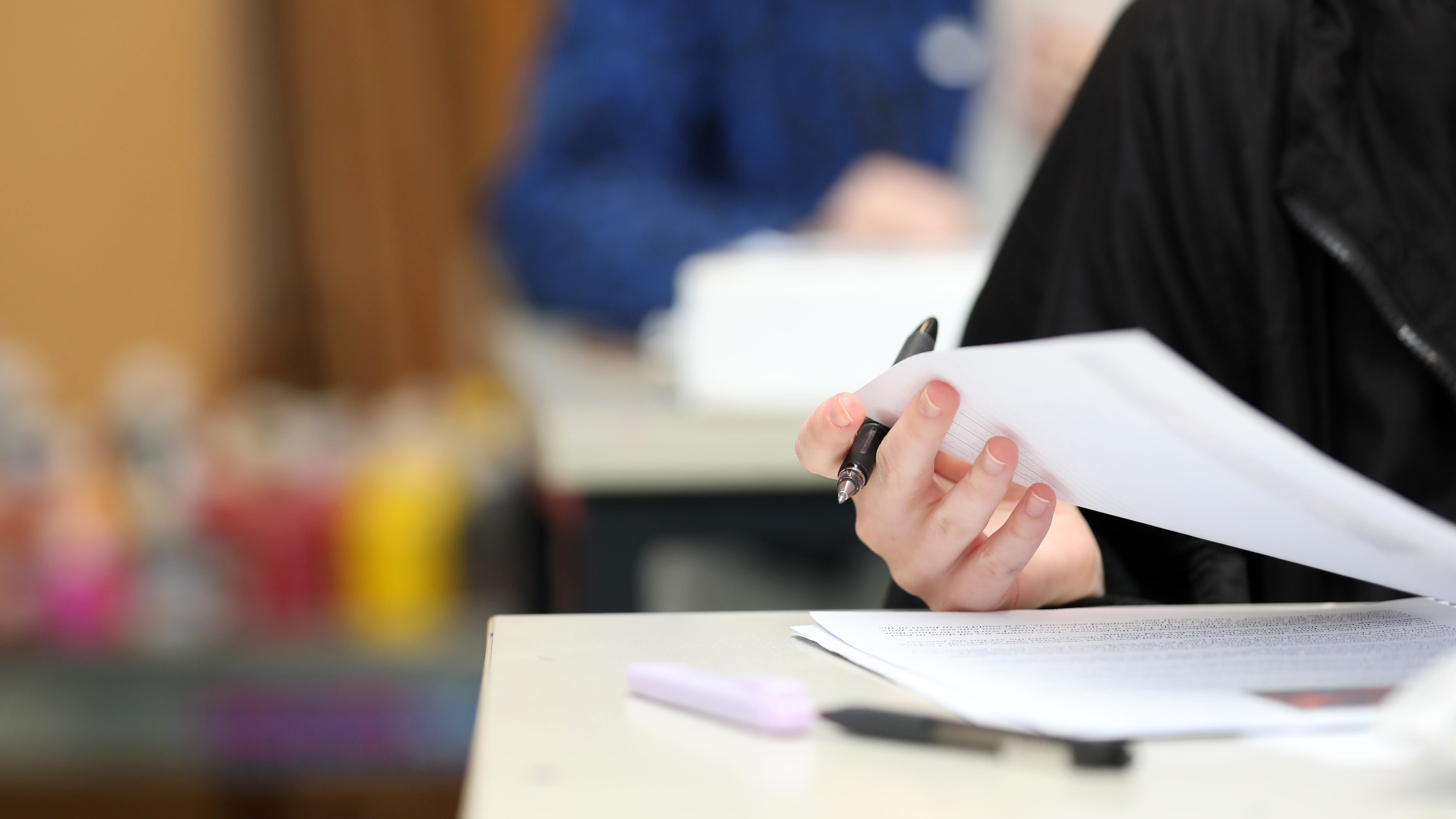 Person at a desk with a pen and papers