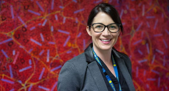 Open Universities Australia student, Melissa, wearing professional clothes in a workplace setting.