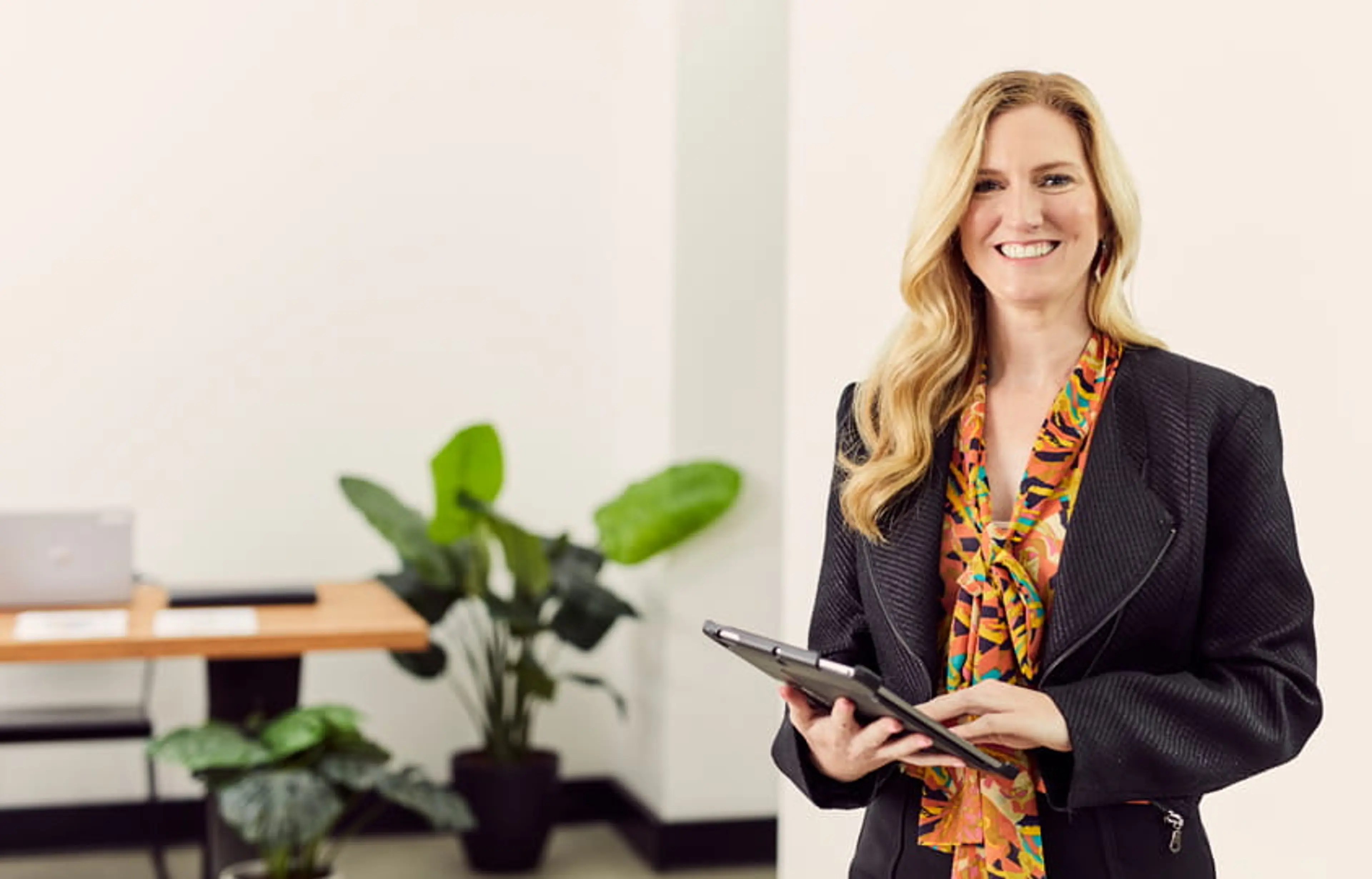 Open Universities Australia student, Nessa, wearing professional clothes, standing in a workplace setting.