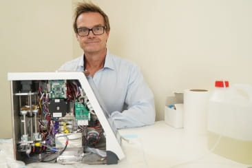 Open Universities Australia student Peter, seated in a laboratory.