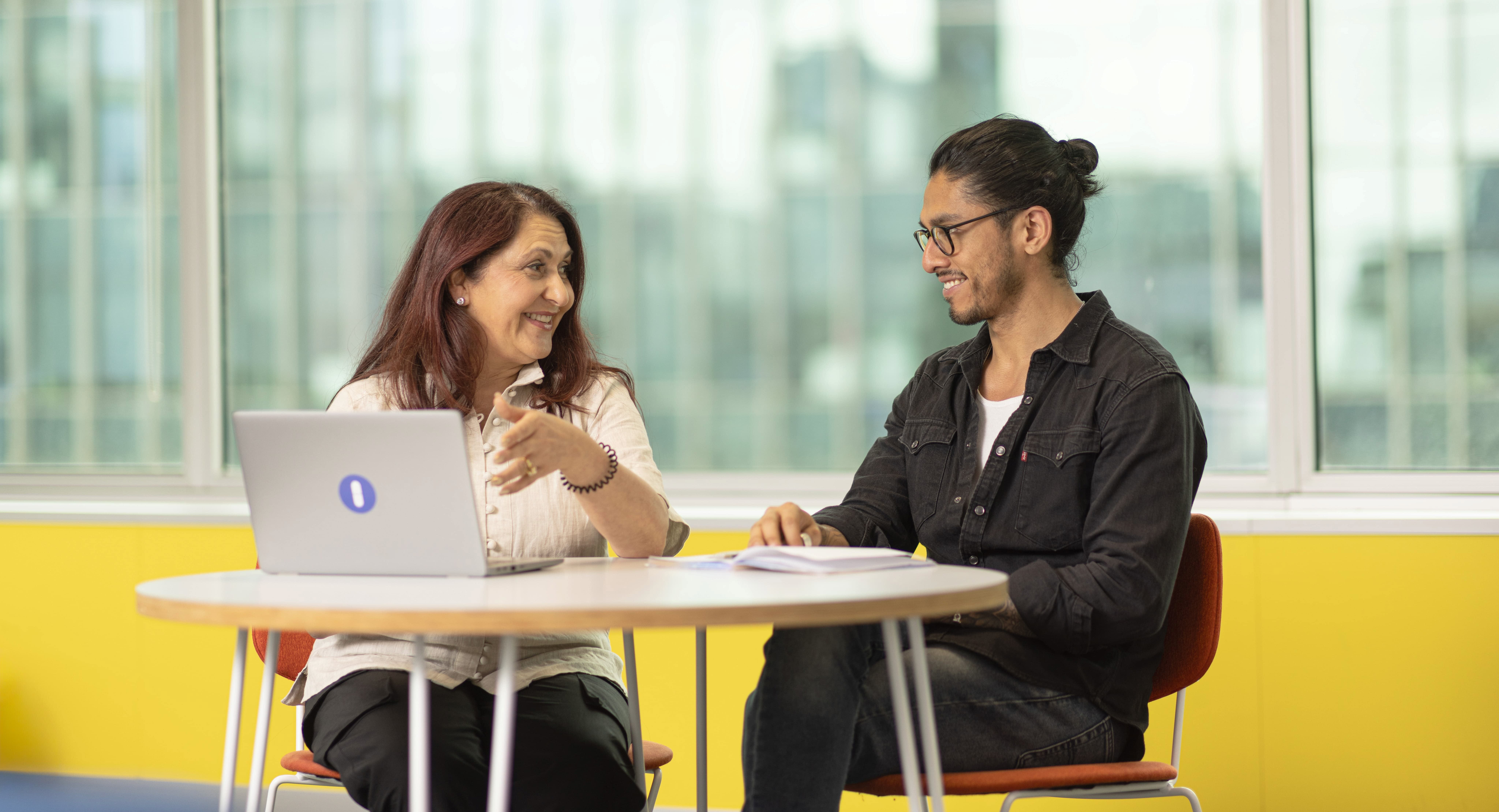 Open Universities Australia student advisors, Maria and Eddie, seated in the office.