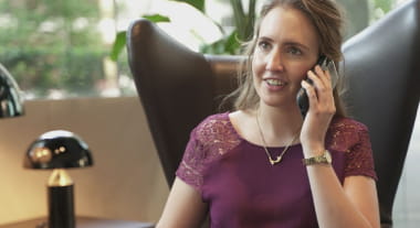 Open Universities Australia student, Faye, using a smart phone in a corporate setting.
