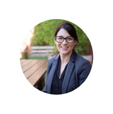 Open Universities Australia student, Melissa, wearing professional clothes, seated outdoors.